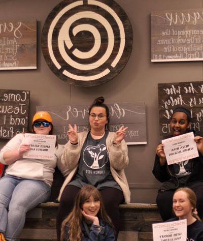 5 Girls posing, 3 holding name cards